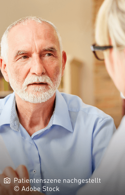 Älterer Mann 70+ hört einer Ärztin aufmerksam zu: Mastozytose tritt in verschiedenen Subtypen und mit unterschiedlichen Symptomen auf.